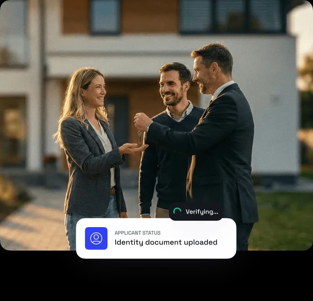 A smiling woman receives house keys from a man in a suit, with another man standing nearby, outside a modern home.